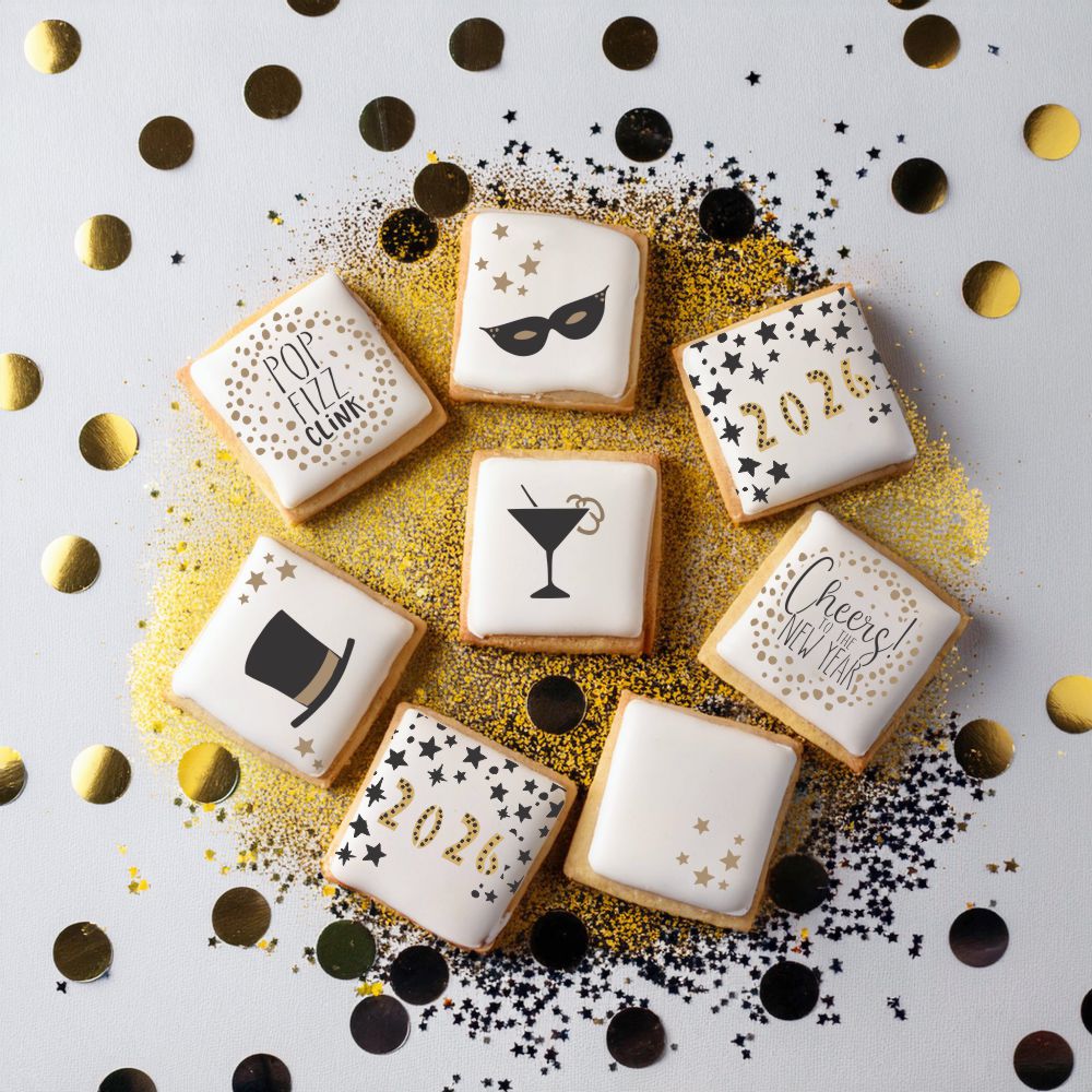 Decorative cookies with New Year's Eve designs on a white background with gold and black confetti.