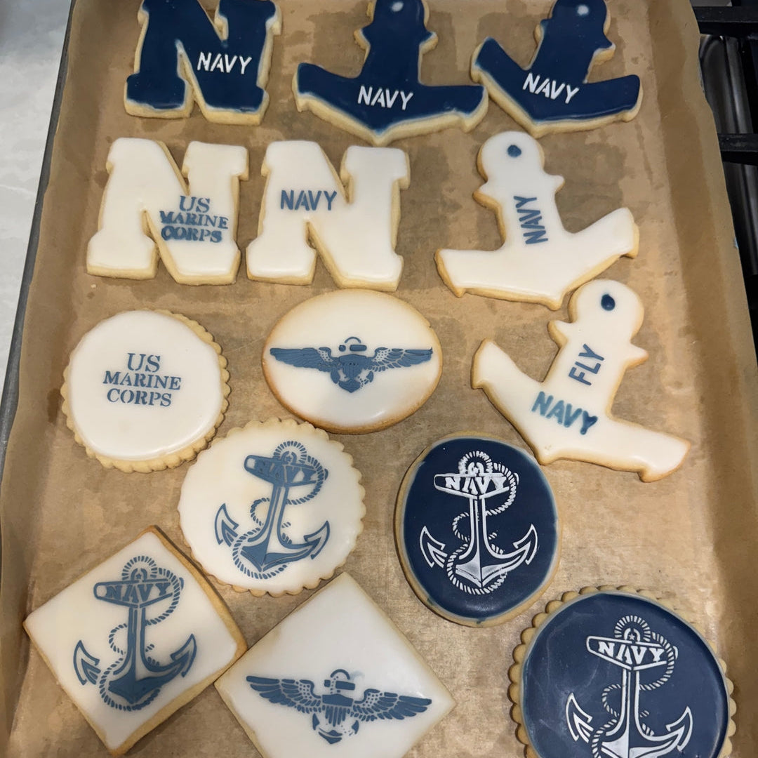 Cookies with navy and Marine Corps symbols on a baking sheet.