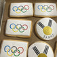 Cookies with Olympic rings and a design resembling the flag of Holland on a baking sheet.