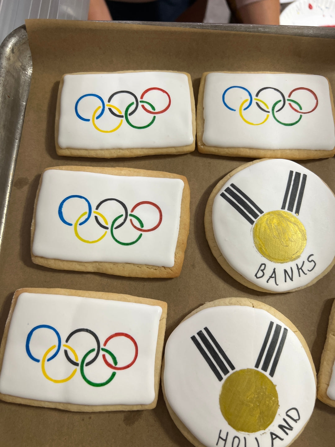 Cookies with Olympic rings and a design resembling the flag of Holland on a baking sheet.