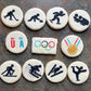 Decorative cookies with Olympic-themed designs on a stone surface