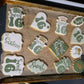 Decorative cookies with 'Sweet 16' designs on a baking tray.