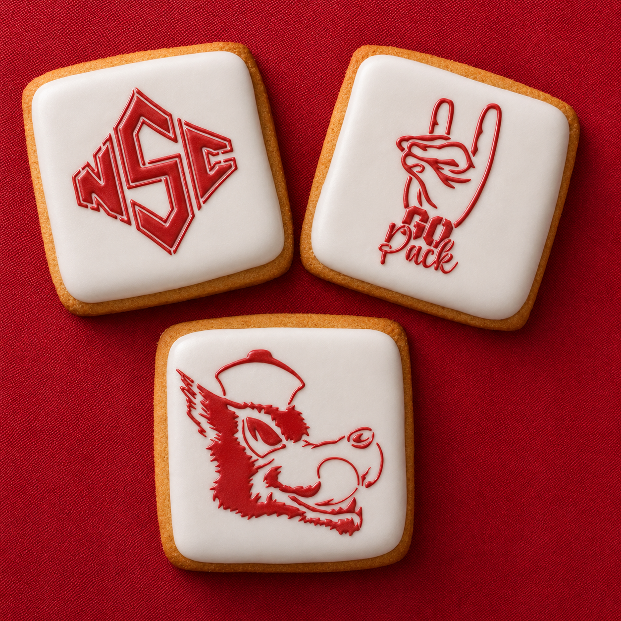 Go Pack Go Cookie Stencil Set applied to three white iced cookies for a NC State party