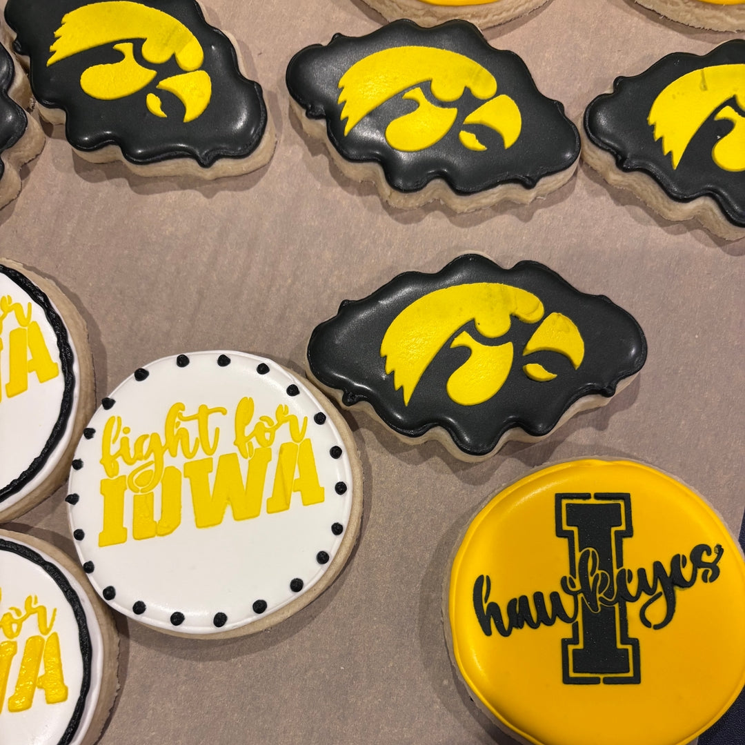 Cookies with Iowa Hawkeyes branding on a brown surface