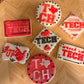 Decorative cookies with 'TECH' and other text designs on a wooden board.