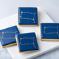 Cookies with blue icing and stenciled gold Gemini star constellation.