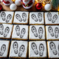 Cookies with Santa Claus footprints and 'Santa Claus' text on a festive background with Christmas decorations.