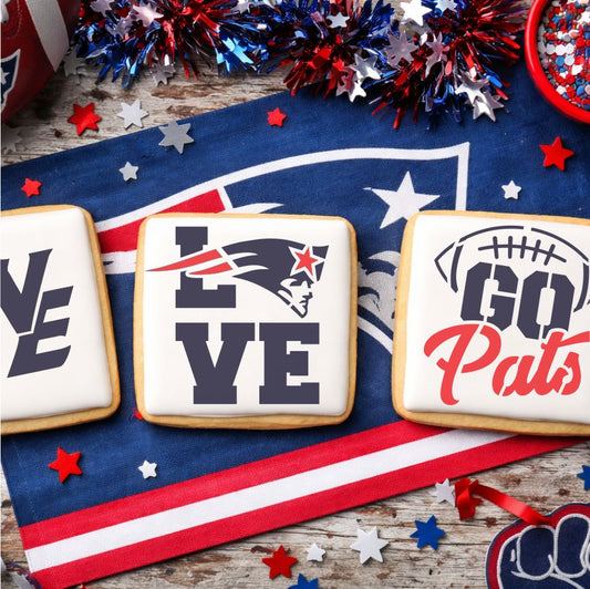 White iced cookies with Patriots-inspired designs on a tablecloth with sports team logos