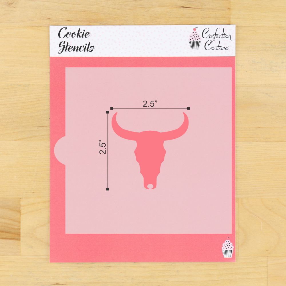 A package of Confection Couture cookie stencils featuring a pink bull skull design with 2.5-inch dimensions, displayed on a light wood background.