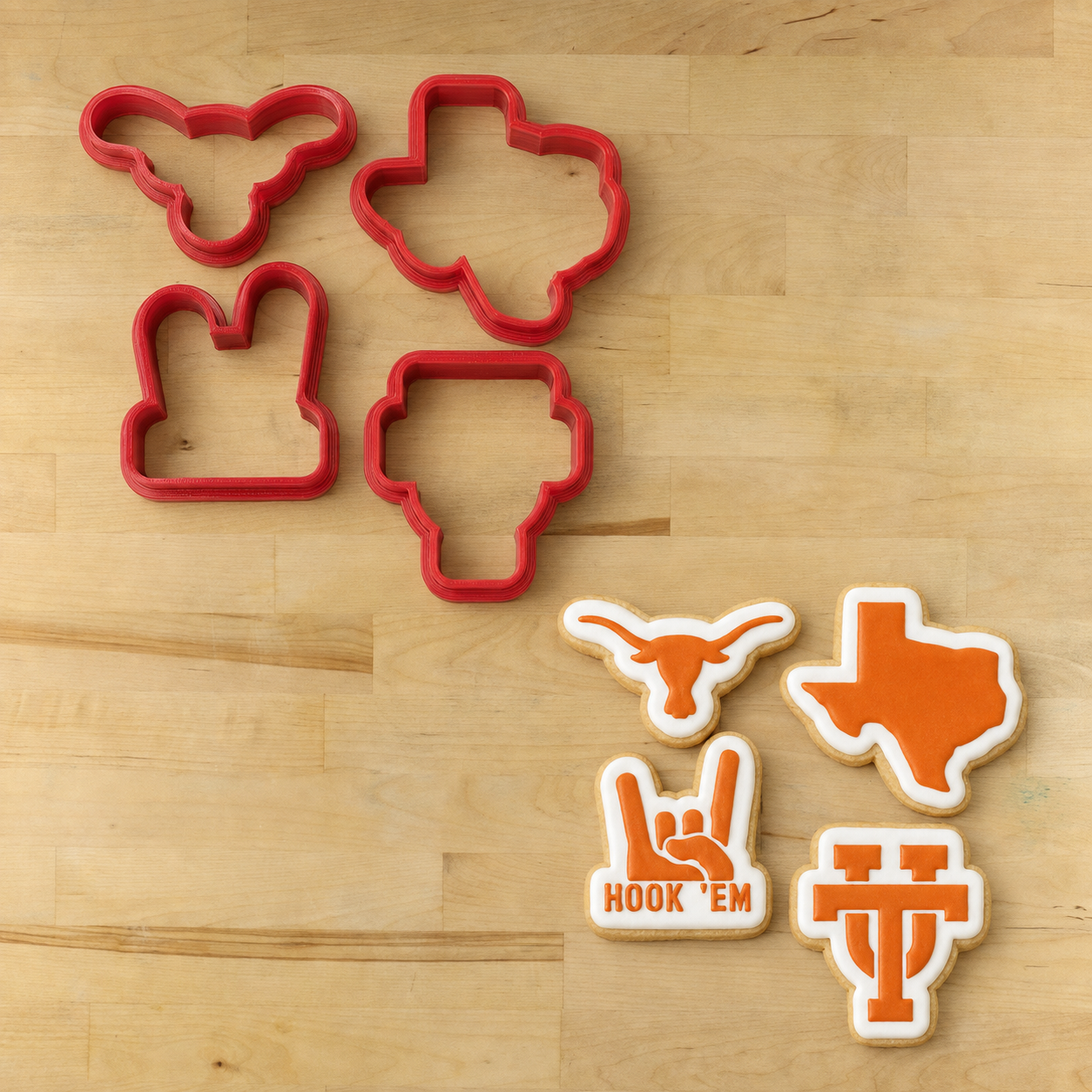 Four red cookie cutters arranged on a light wood surface, with four decorated cookie cutouts below in the shapes of a longhorn, Texas state outline, rock hand sign with 'HOOK 'EM' text, and Texas Tech logo.