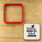 A square red cookie cutter and a square white cookie with a black 'Welcome Back to School' design featuring an apple and pencil, displayed on a light wood background.