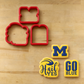 Michigan Wolverines Cookie Cutters lying next to three cookies decorated with the matching "Hail Yes" Cookie Stencil Set