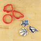 Go Jays cookie stencil set with cookie cutters and basketball-themed decorations on a wooden surface.