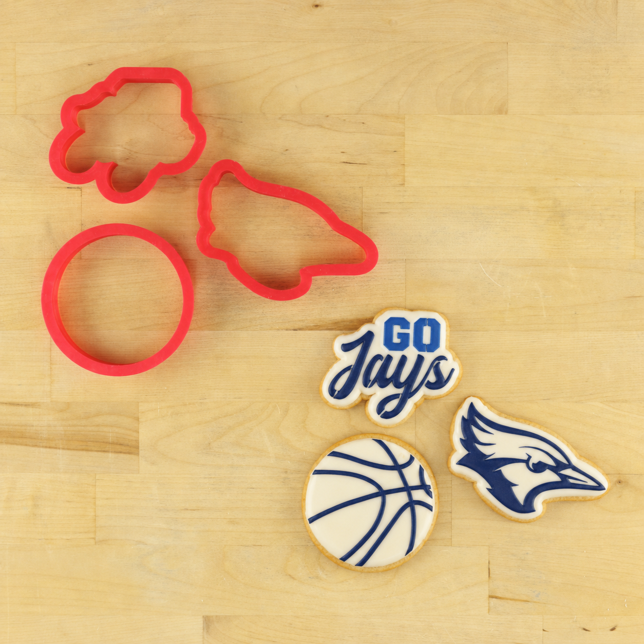 Go Jays cookie stencil set with cookie cutters and basketball-themed decorations on a wooden surface.