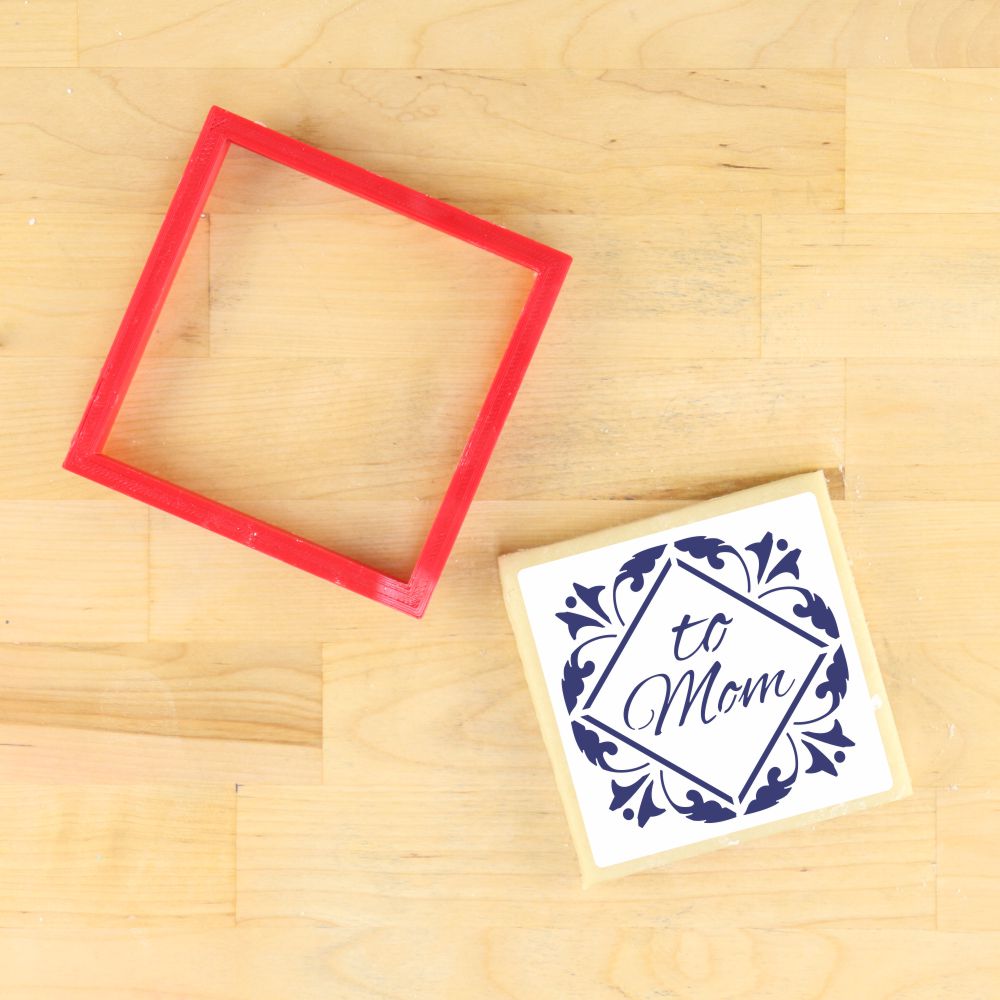 To Mom tile cookie stencil with red frame and decorated cookie, perfect for Mother's Day baking.