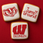 Three cookies with red and white icing on a red background, featuring a logo and text.