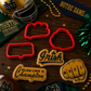 Collection of Notre Dame-themed cookie cutters and accessories on a wooden surface.