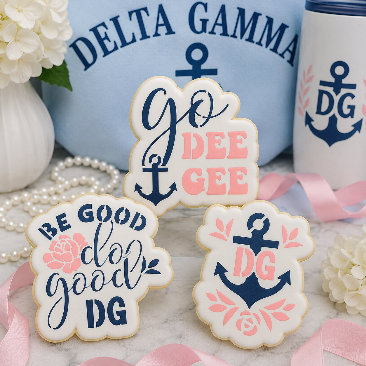 Three decorated Delta Gamma sugar cookies displayed with anchor-themed sorority décor in blue and pink.