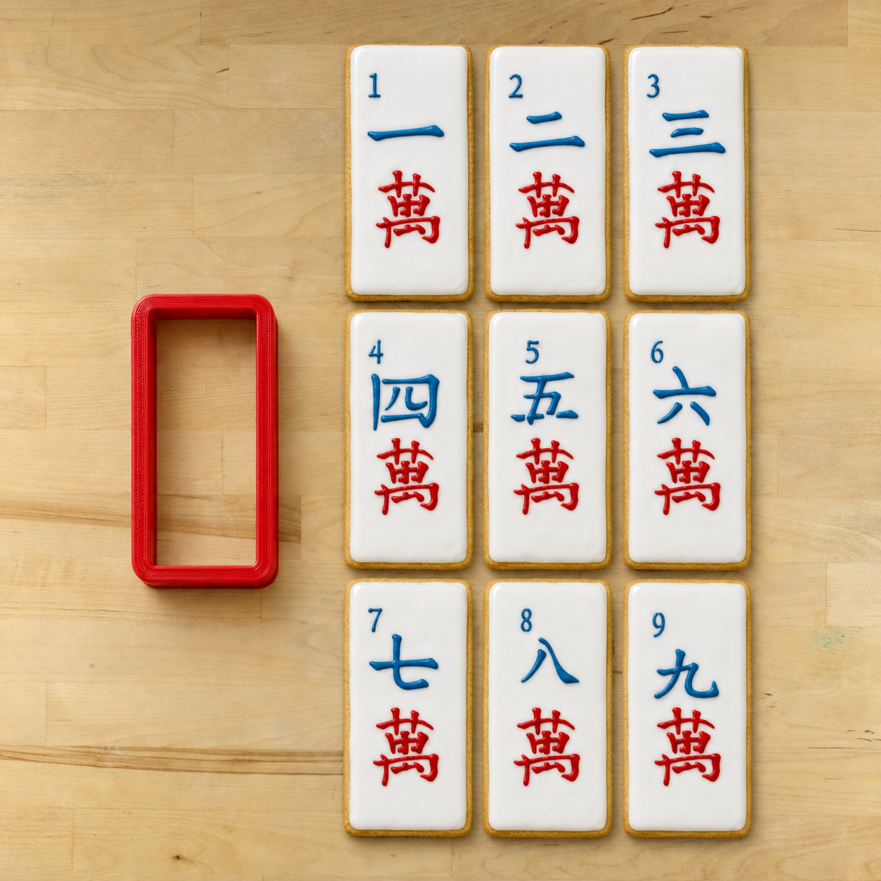 rectangle cookie cutter next to 9 cookies decorated with Mahjong Crak Tile cookie stencils