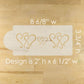 Wooden mold with heart designs on a wooden surface, showing measurements.