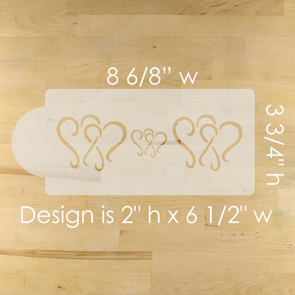 Wooden mold with heart designs on a wooden surface, showing measurements.