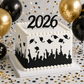 Graduation Silhouette Cake Stencil applied to the sides of a white cake on a table decorated for graduation.