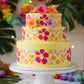 Hibiscus flower design on the side of a yellow iced caked with a Hawaiian theme luau.
