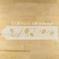 Wooden cutting board with laser-cut design on a wooden surface