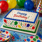 Birthday cake with colorful decorations and balloons on a table with party supplies.