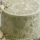 Chic rose cake top stencil applied to a tall, round cake with royal icing