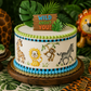 Jungle-themed birthday cake with animal illustrations and 'Wild About You!' topper.