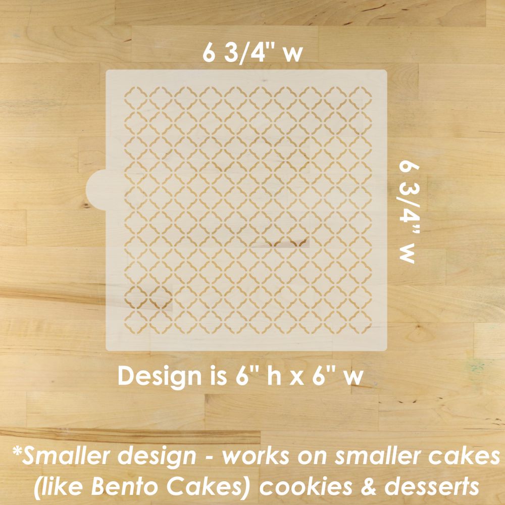 Moroccan quatrefoil patterned cake stencil on a wooden surface with measurements and design dimensions.