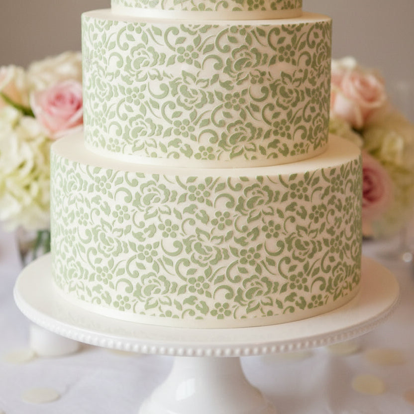 Decorative pattern with floral and swirl designs in light green on a white background