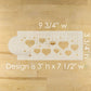 Cake stencil with heart designs on a wooden surface, showing measurements.