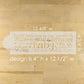 Baby Shower cake stencil on a wooden surface with the stencil dimensions.