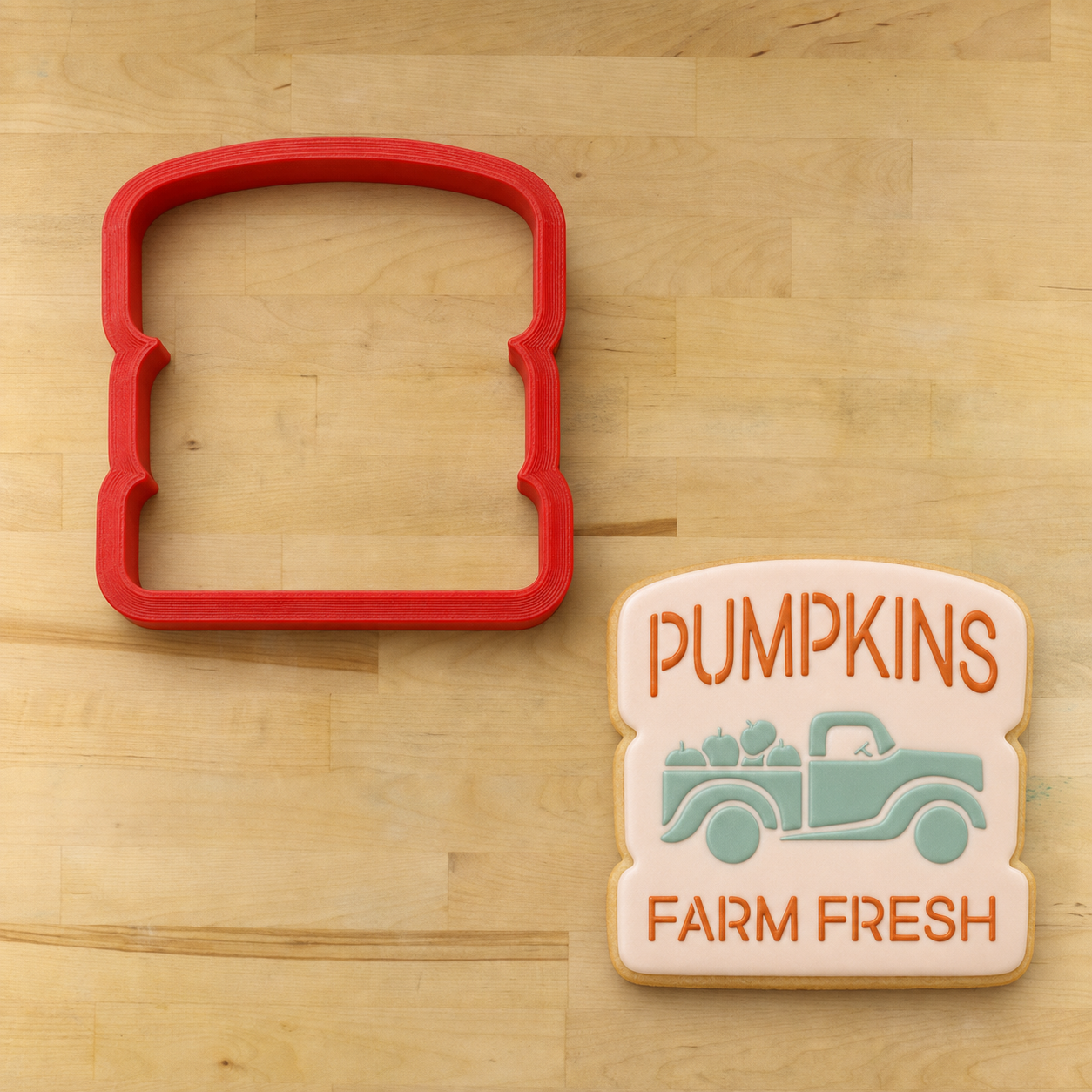 Vintage Pumpkin Truck Cookie Stencil applied to an iced cookie, lying next to the matching cookie cutter