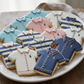 Decorative cookies shaped like shirts on a white plate.